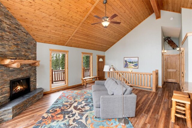 living room featuring beam ceiling, ceiling fan, a stone fireplace, wood ceiling, and hardwood / wood-style flooring