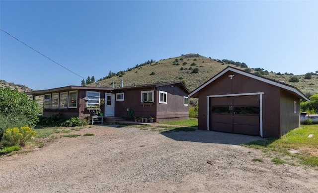 ranch-style house with a mountain view, an outbuilding, and a garage