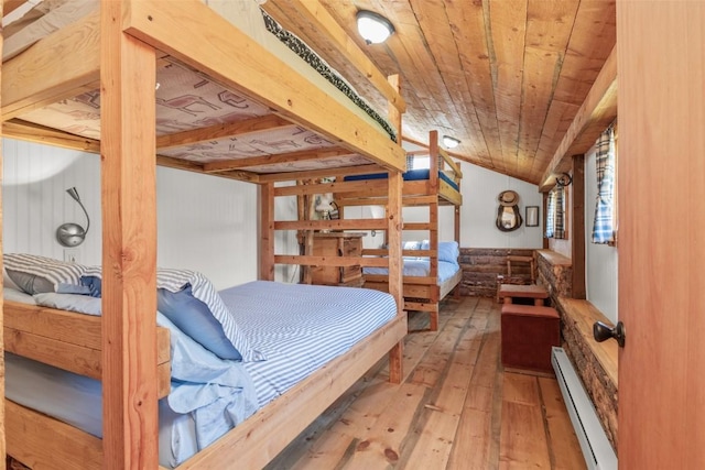 bedroom featuring hardwood / wood-style flooring, wood walls, wooden ceiling, and baseboard heating