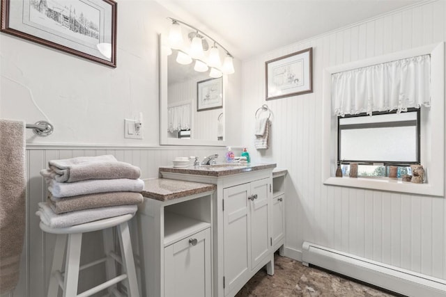 bathroom featuring baseboard heating, wood walls, and vanity