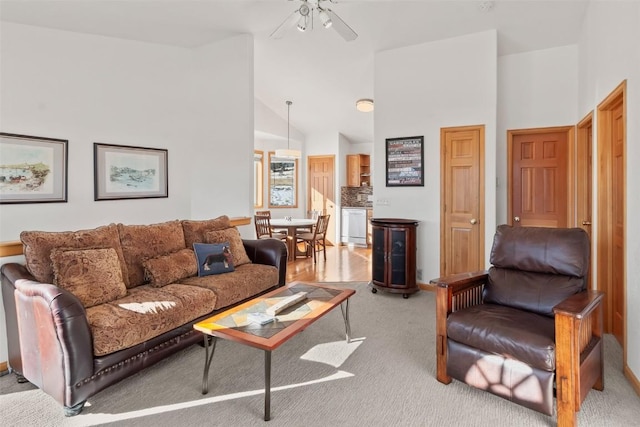 living room featuring ceiling fan, light colored carpet, and vaulted ceiling