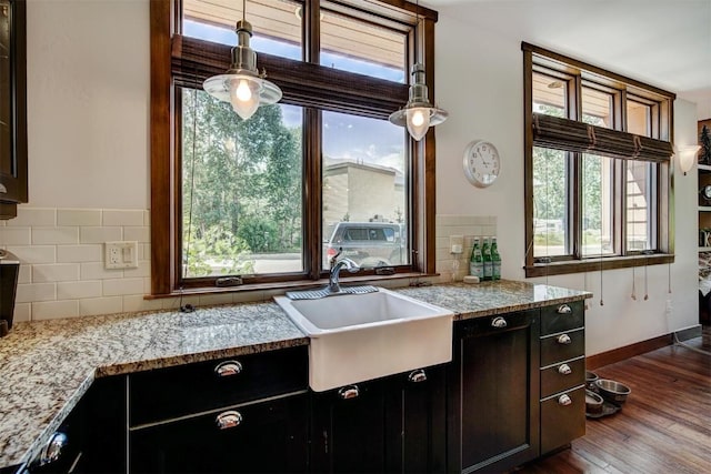 kitchen featuring dark hardwood / wood-style flooring, tasteful backsplash, a healthy amount of sunlight, and sink