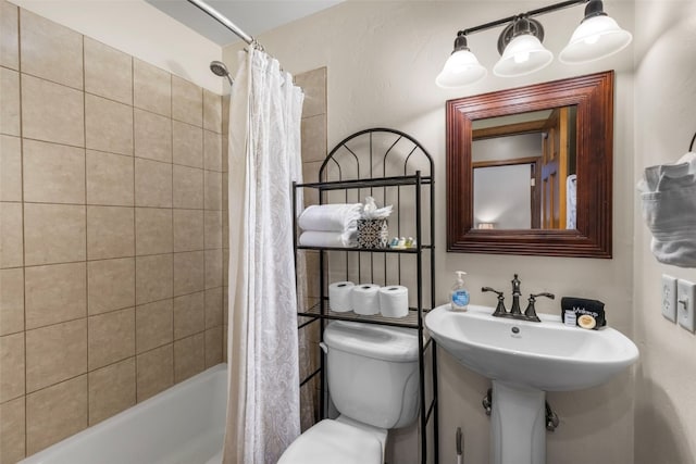 full bathroom featuring sink, toilet, and shower / bath combo with shower curtain