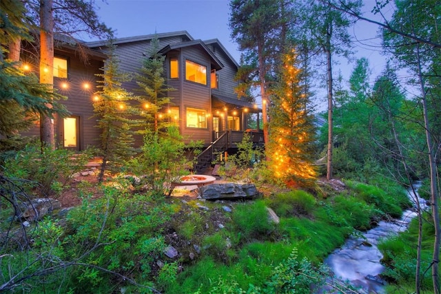 view of side of home with an outdoor fire pit and stairway