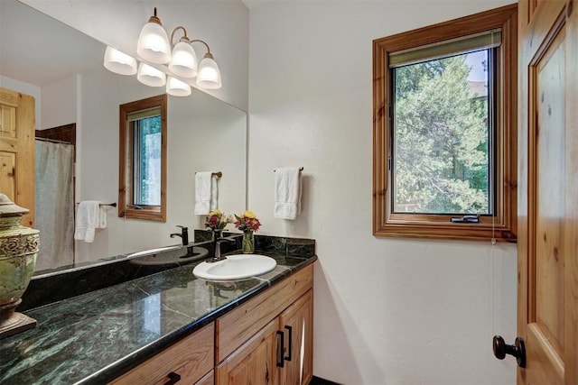 full bathroom with an inviting chandelier and vanity