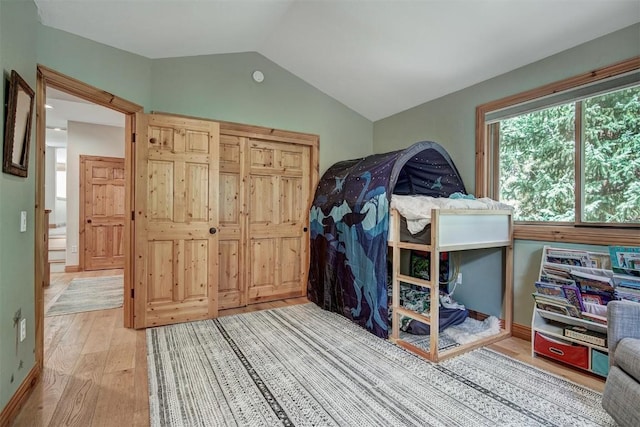 bedroom with vaulted ceiling and hardwood / wood-style floors