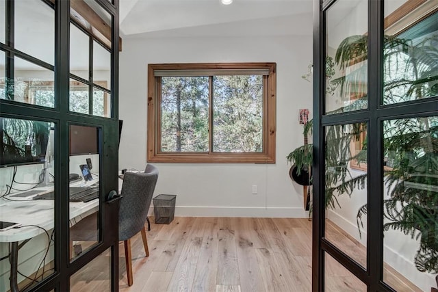 office with light wood finished floors, baseboards, and vaulted ceiling