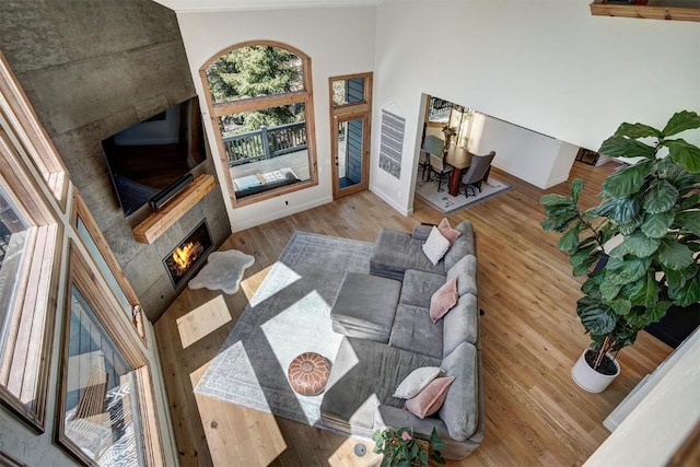 living room with a fireplace, baseboards, and wood finished floors