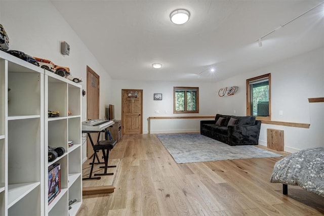 interior space featuring baseboards, track lighting, and wood finished floors