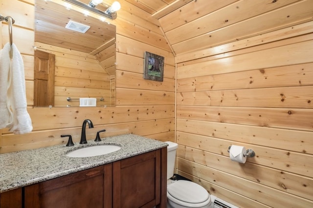 bathroom with toilet, wood ceiling, wooden walls, and vanity