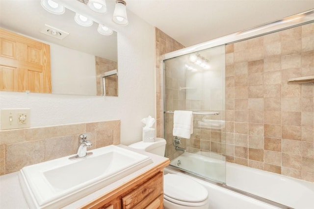 full bathroom with vanity, enclosed tub / shower combo, and toilet