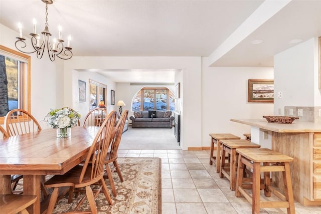 tiled dining room featuring a chandelier