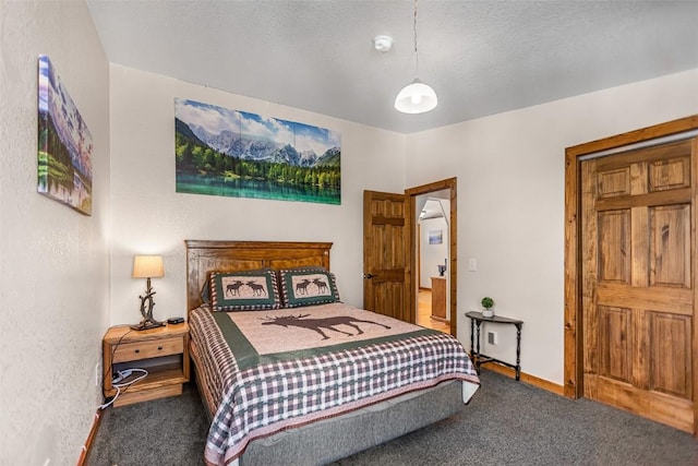 carpeted bedroom featuring baseboards and a textured ceiling