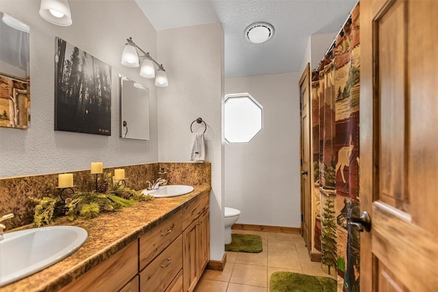 full bathroom featuring toilet, tile patterned flooring, double vanity, and a sink