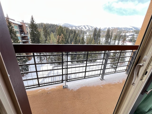 snow covered back of property with a mountain view