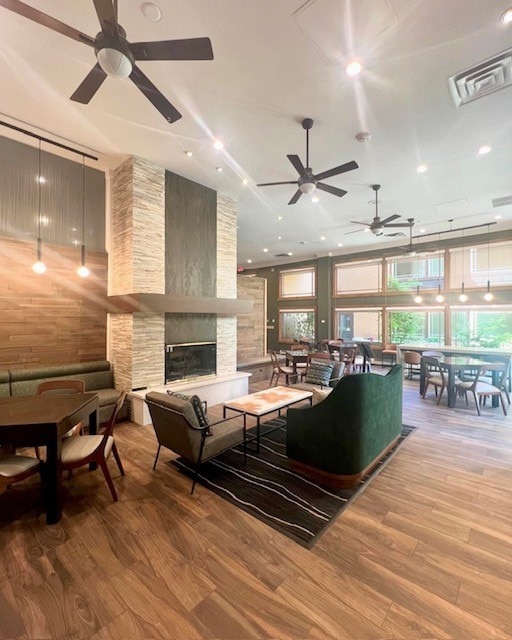 living room with a stone fireplace and light hardwood / wood-style floors