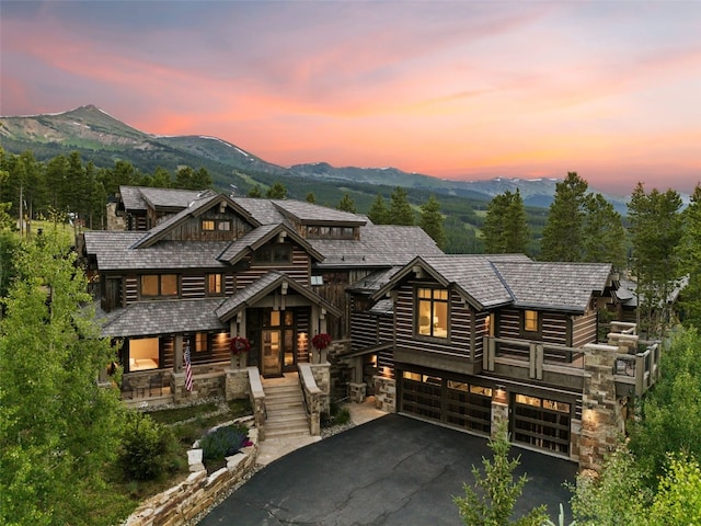 log home with covered porch, a mountain view, and a garage