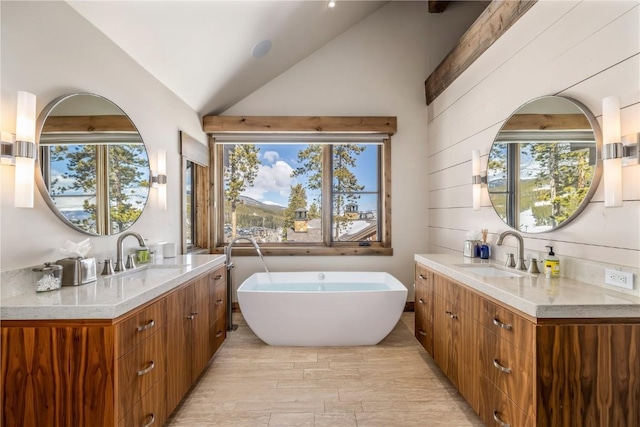 bathroom with vanity, vaulted ceiling, wooden walls, plenty of natural light, and a bathing tub