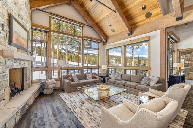 sunroom featuring vaulted ceiling with beams, plenty of natural light, wooden ceiling, and a fireplace