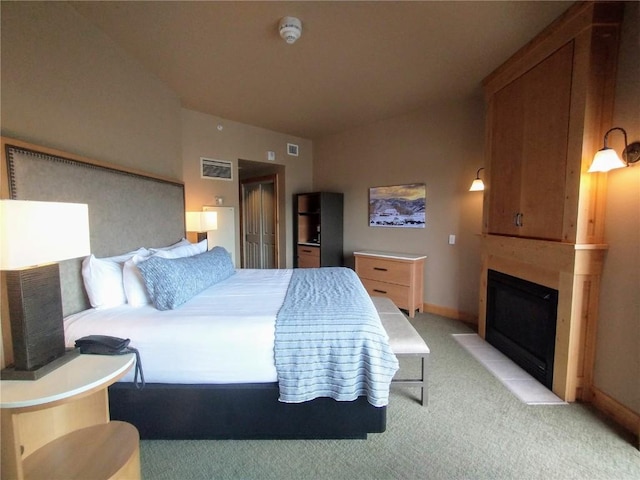 bedroom with visible vents, a large fireplace, baseboards, light colored carpet, and vaulted ceiling