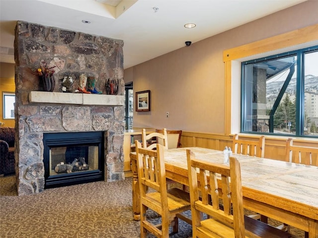 carpeted dining area with a fireplace