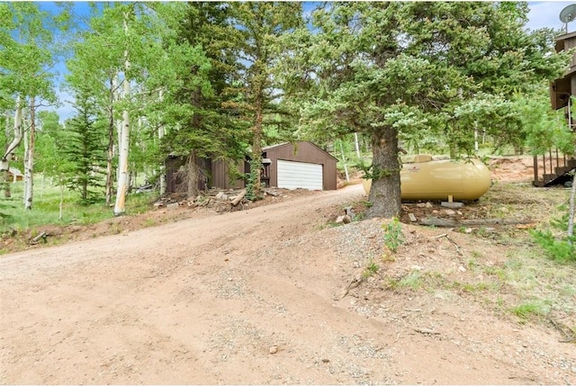 view of yard with a garage and an outbuilding