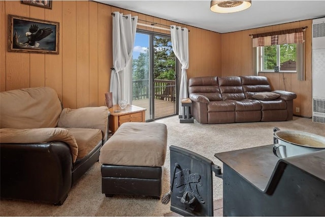 living room featuring a wealth of natural light, light carpet, and wood walls