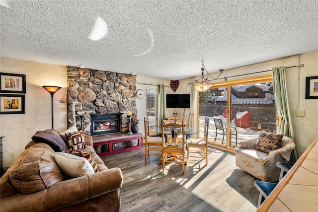 living room featuring hardwood / wood-style floors, a textured ceiling, and a fireplace