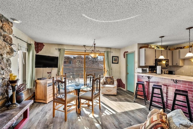 dining room featuring light hardwood / wood-style flooring and a textured ceiling