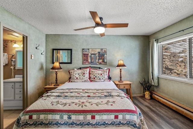 bedroom featuring a baseboard heating unit, hardwood / wood-style floors, a textured ceiling, and ceiling fan