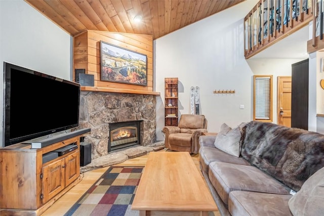 living room with light wood-type flooring, a stone fireplace, lofted ceiling, and wood ceiling