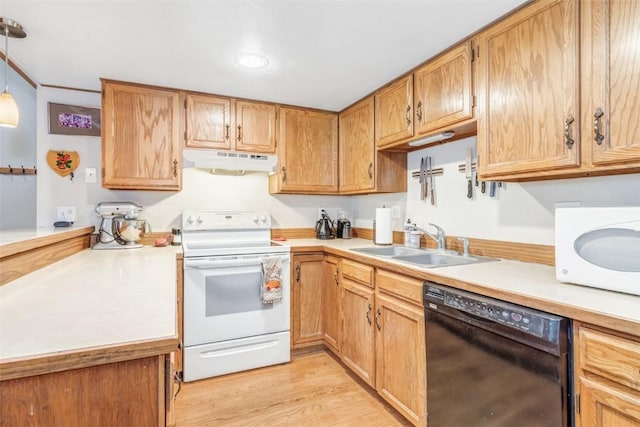 kitchen with decorative light fixtures, white appliances, sink, and light hardwood / wood-style flooring