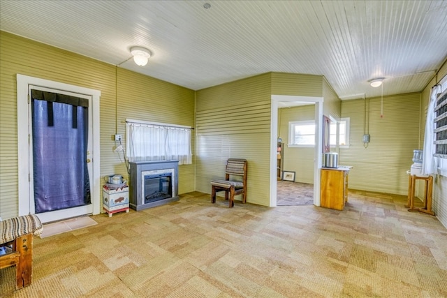 living room with a glass covered fireplace and light carpet