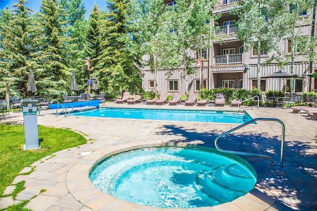 view of pool with a community hot tub and a patio