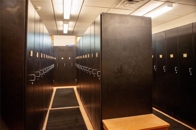 room details with hardwood / wood-style floors, a paneled ceiling, and wooden walls