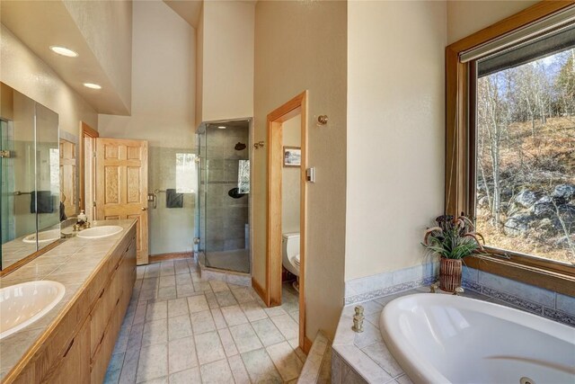 full bathroom with tile patterned floors, vanity, separate shower and tub, and toilet