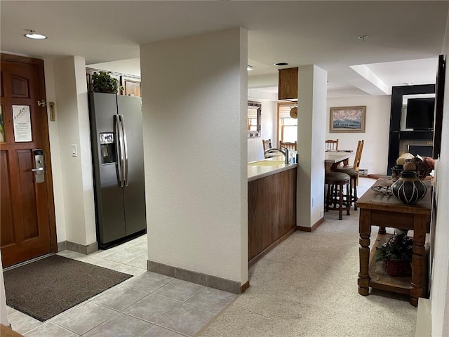 kitchen with light tile patterned floors and stainless steel refrigerator with ice dispenser