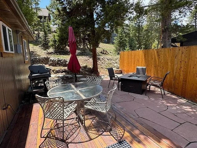 view of patio / terrace with outdoor dining area, fence, a fire pit, and grilling area