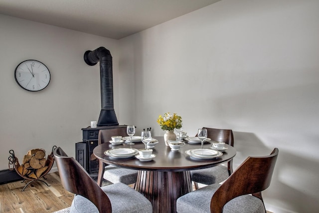 dining area featuring light hardwood / wood-style flooring and a wood stove