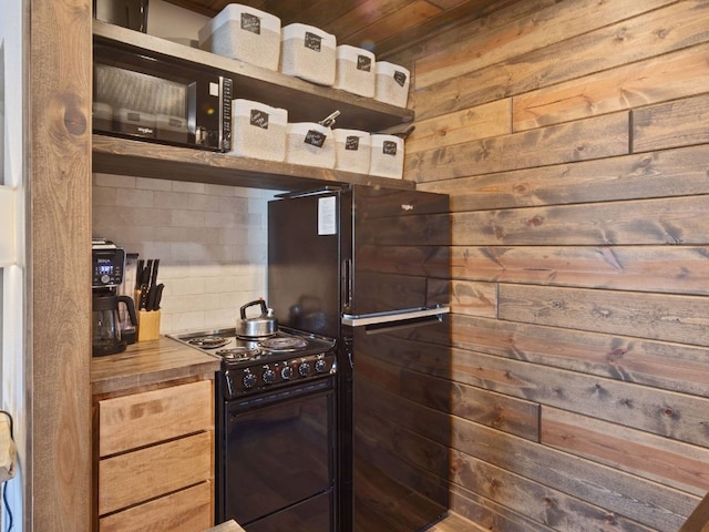 kitchen featuring tasteful backsplash, black range with electric stovetop, and wooden walls