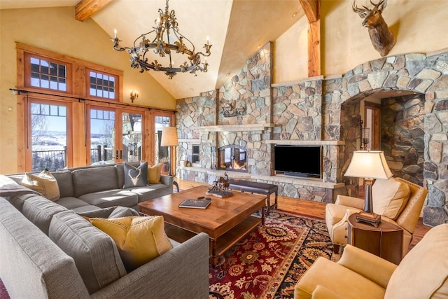 living room with high vaulted ceiling, beamed ceiling, an inviting chandelier, and a stone fireplace