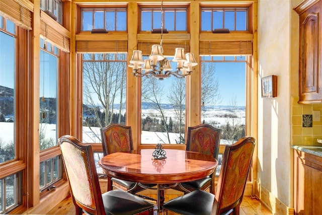 dining room with light hardwood / wood-style floors and a notable chandelier