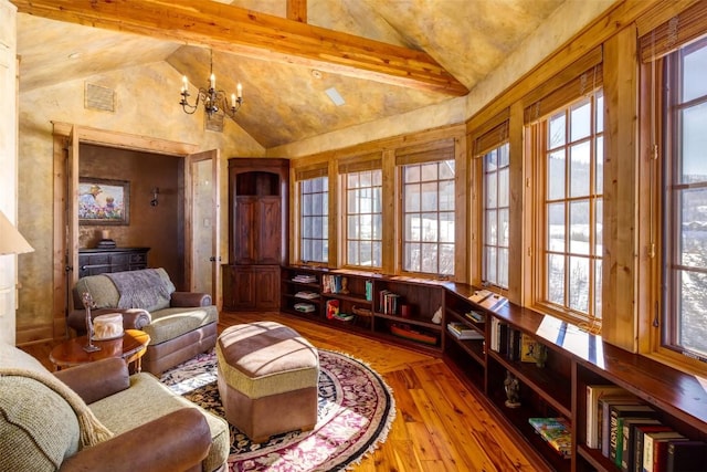 sitting room with light hardwood / wood-style floors, beamed ceiling, high vaulted ceiling, and an inviting chandelier