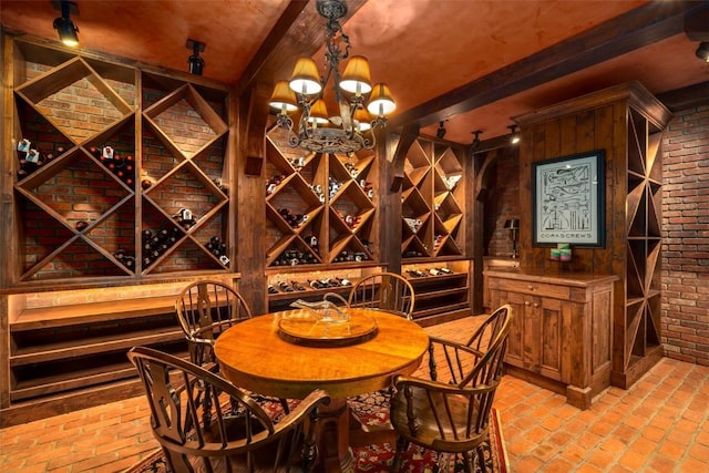 wine room featuring brick wall, beamed ceiling, and a notable chandelier