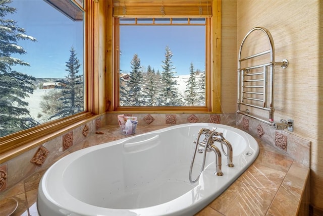 bathroom with a healthy amount of sunlight and tiled tub