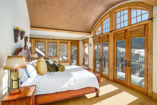 carpeted bedroom with access to exterior, french doors, and lofted ceiling