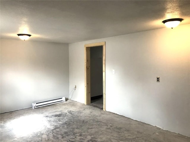 unfurnished room with concrete flooring and baseboard heating