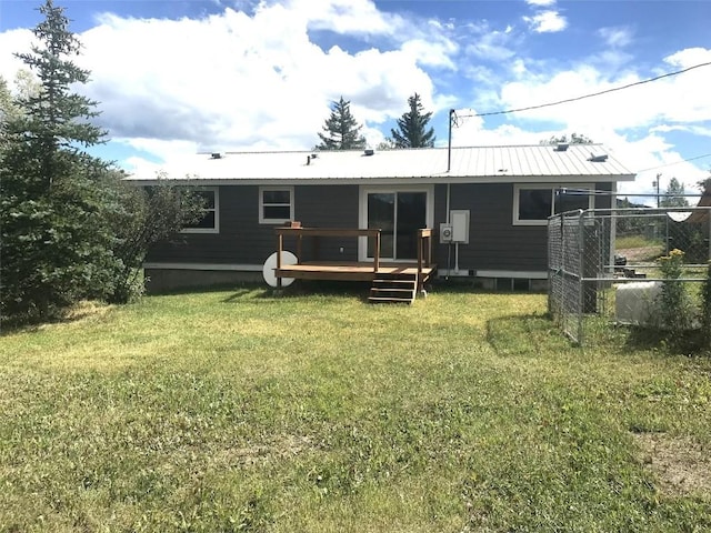 back of house with a yard, metal roof, a deck, and fence