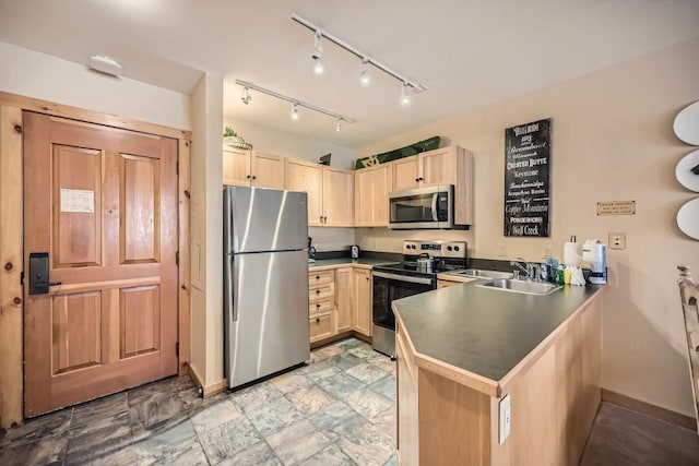 kitchen with light brown cabinets, kitchen peninsula, sink, and appliances with stainless steel finishes