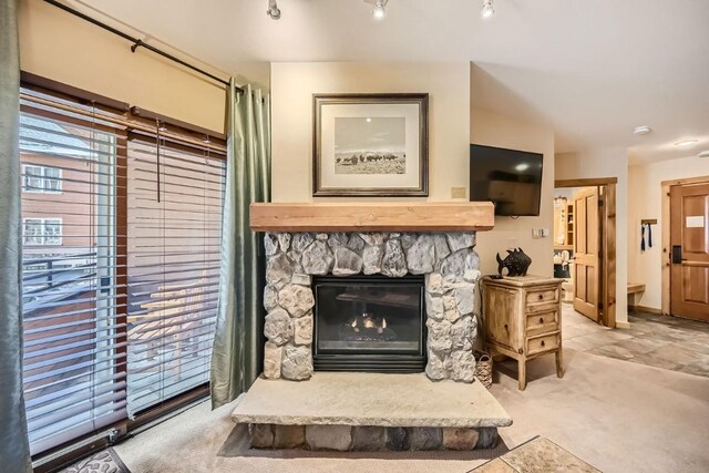 living room with light carpet and a stone fireplace